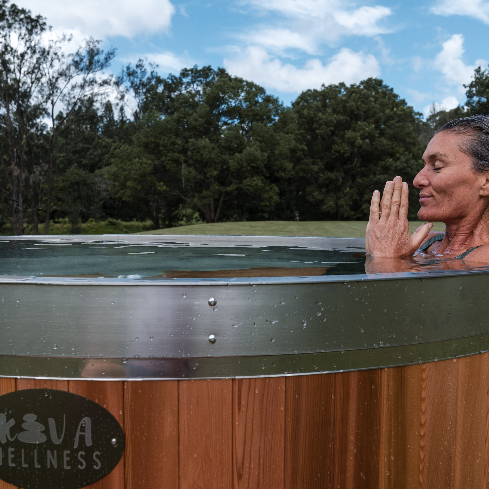 Woman immersed in a Kiva Wellness ice bath, embracing the calm of cold water therapy.