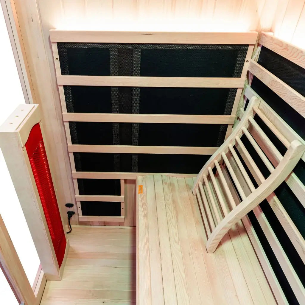 Overhead view inside a Kiva Wellness Radiance 4 person sauna showing the bench, backrests and heater panels.