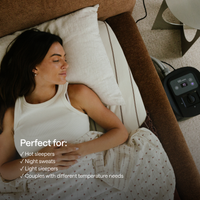 A woman sleeping under a white patterned duvet, using a Kiva circadian sleep pod and its mattress topper.