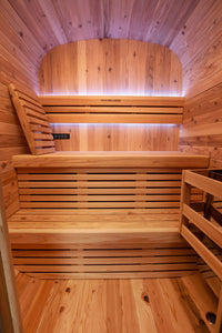 Kiva Wellness Ritual 3 person timber front sauna interior with illuminated benches, a backrest and a guarded heater.