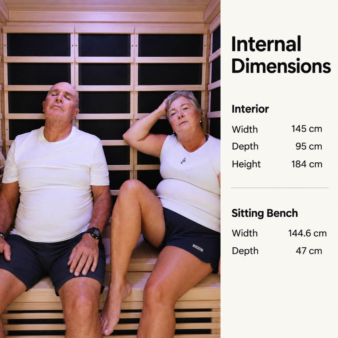 A man and a woman sit inside a wooden 3 person kiva wellness sauna with text on the right listing internal dimensions: interior width 145 cm, depth 95 cm, height 184 cm, and sitting bench width 144.6 cm and depth 47 cm.