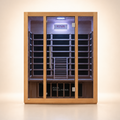 A Kiva Wellness infrared sauna with a light wood exterior, glass door, and a dark panels and LED lighting, centered against a clean beige studio background.