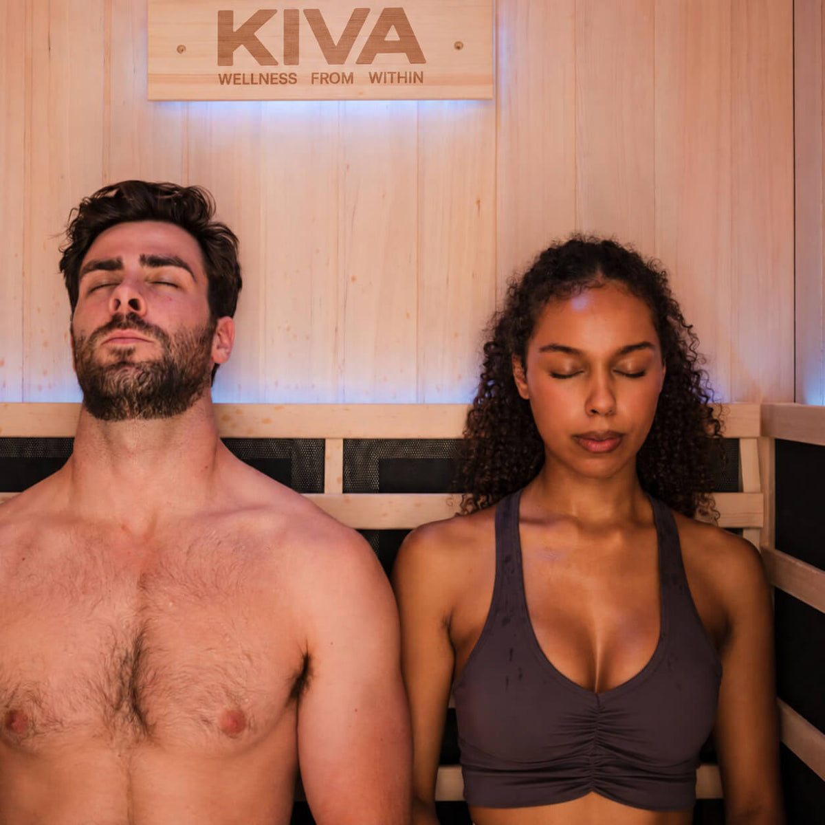 Couple relaxing inside a Kiva Radiance full spectrum infrared sauna with timber interior and ergonomic seating.