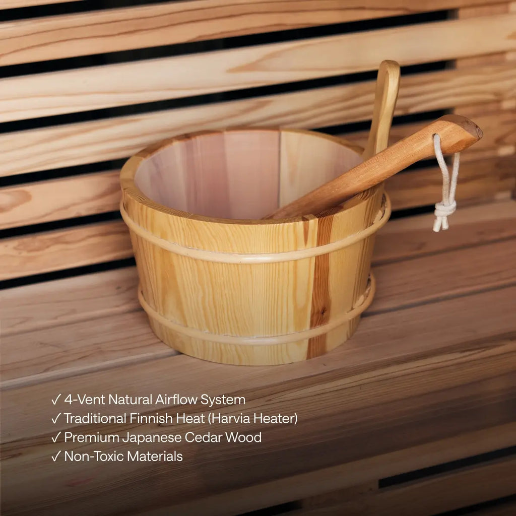 Wooden bucket and ladle on a Kiva Wellness Ritual sauna bench, with an overlay describing cabin features.
