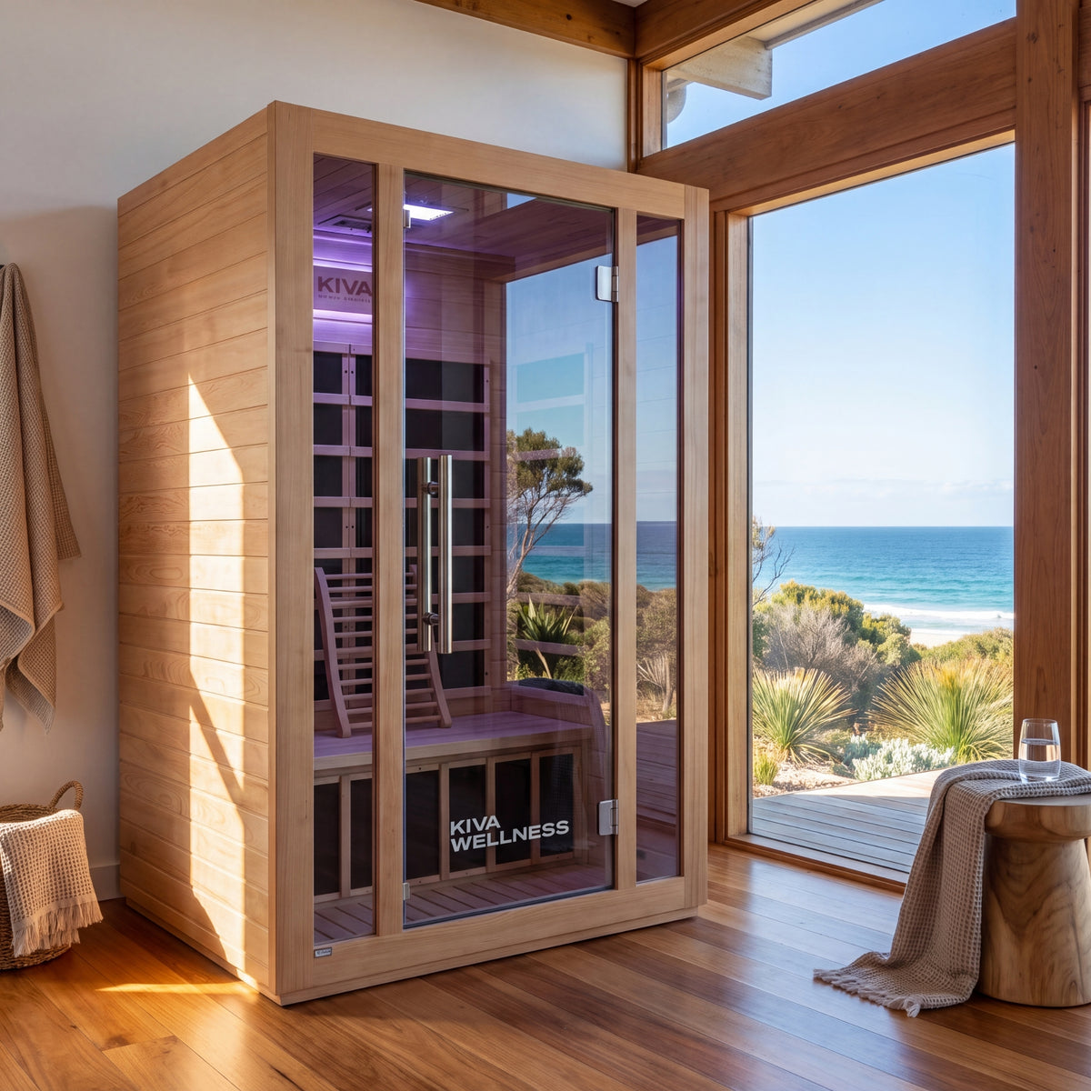 Kiva Wellness Rise 2 person sauna beside timber-framed windows with an ocean view.
