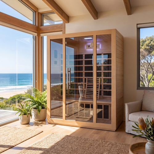Kiva Rise 3 Person far infrared sauna, placed in a bright coastal room with large windows overlooking the ocean